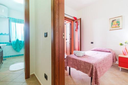 a room with a bed with a table and a mirror at Residence La Corte Di Anastasia in Torpè