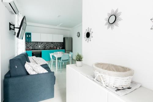 a living room with a blue couch and a kitchen at Le Isole di Anita in Lipari
