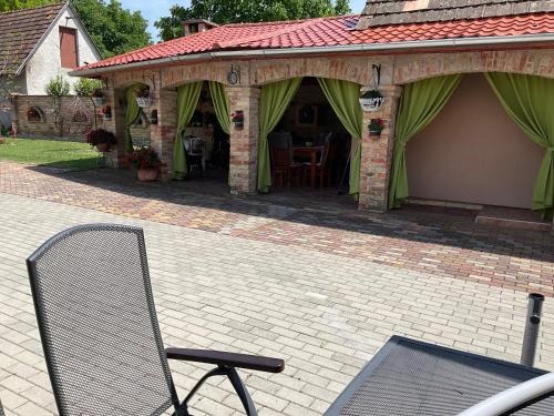 a chair in front of a house with a pavilion at Jarmila Vendégház in Balatonberény