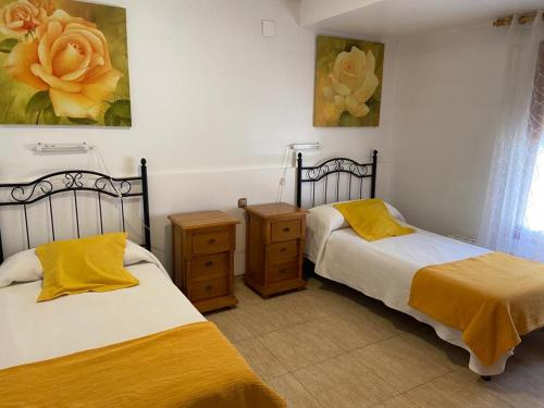 um quarto com duas camas e um quadro na parede em Pensión Santa Rita em Calatayud