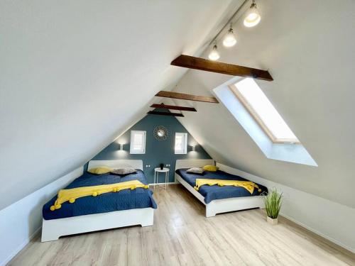 2 camas en un dormitorio del ático con almohadas azules y amarillas en IstEni apartman Zamárdi, akár 12 fő! Balaton, en Zamárdi