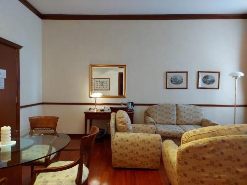 a living room with a couch and a table at Phi Hotel Dei Medaglioni in Correggio