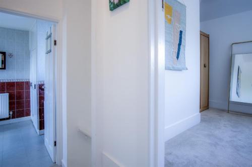 a hallway with white walls and a staircase in a room at Avoca - 3 Bedroom Holiday Home - Llangennith in Llangennith
