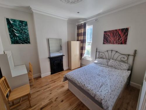 a bedroom with a bed and a chair in it at Tulse Hill Luxury Cosy Rooms in London
