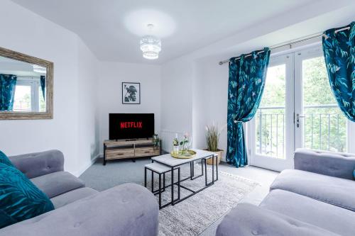 Carterson Serviced Apartment Coventry في كوفينتري: غرفة معيشة مع كنبتين وتلفزيون