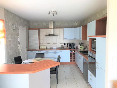 une cuisine avec des armoires blanches et une table à l'intérieur dans l'établissement ELFES - Proche des Salines, Plage 500m - K44, à Carnac