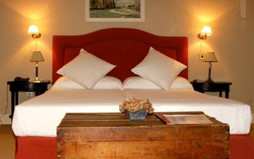 a bedroom with a large bed with a wooden headboard at Posada Real Casa de Tepa in Astorga
