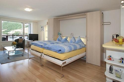 um quarto com uma cama grande e almofadas azuis em Adler 87 em Leukerbad