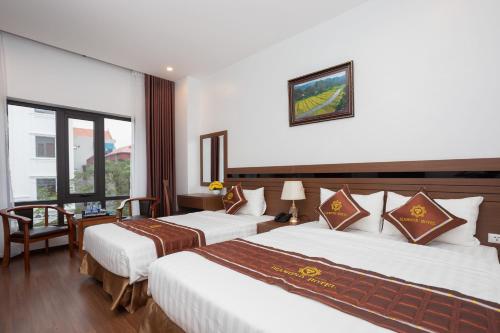 a hotel room with two beds and a window at Diamond Hotel in Ninh Binh
