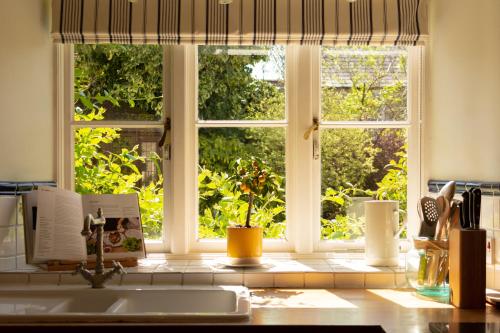 a kitchen counter with a window and a sink at Casina Cottage in Quenington