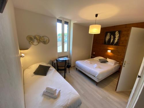 um quarto de hotel com duas camas e uma mesa em Le Relax em Boulazac