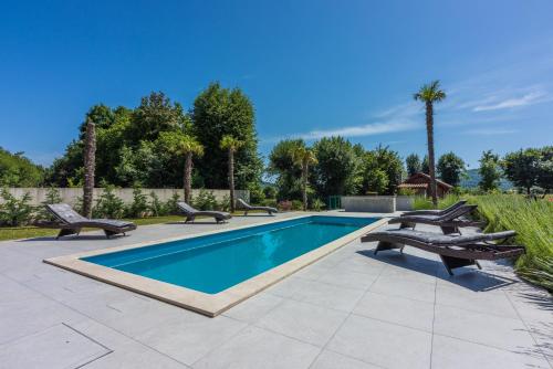 - une piscine avec deux bancs et un bain à remous dans l'établissement Villa Palma with Heated Private Pool, à Podhum