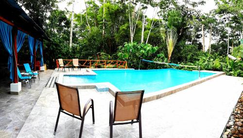 Tropical Paradise Bungalows في Pital: مسبح بجانبه طاولة وكراسي