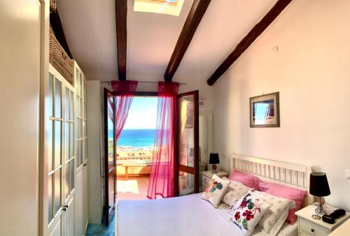 a bedroom with a bed with a view of the ocean at Residence Lu Bagnu in Castelsardo