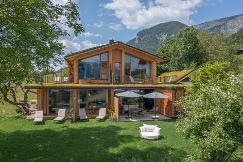 a wooden house with a deck and chairs in a yard at Balthasar Volcano Apartments - Adults only in St. Wolfgang