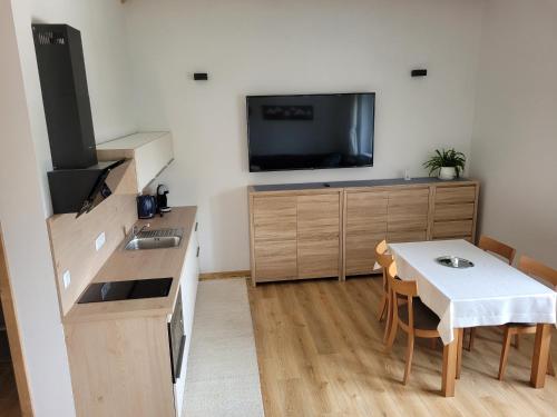 a small kitchen with a table and a tv in a room at Žiar Apartmány 43 in Žiar
