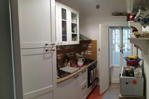 kuchnia z białymi szafkami i białą lodówką w obiekcie La luminaria w mieście Bari