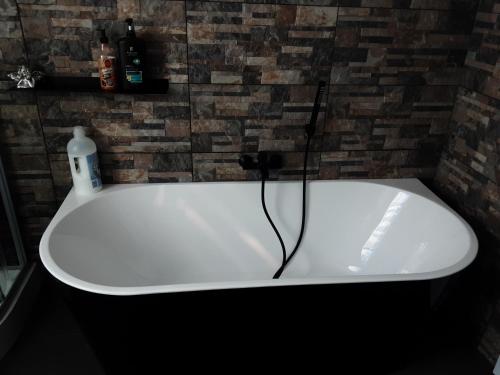 a white bath tub in a bathroom with a brick wall at D'n Engel in Sittard