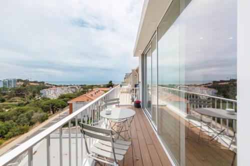 a balcony with tables and chairs and a view of the ocean at Ocean Apartment by Olala Homes in Cascais