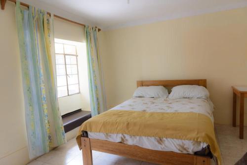 1 dormitorio con cama y ventana en la casa de la guajira en Cusco