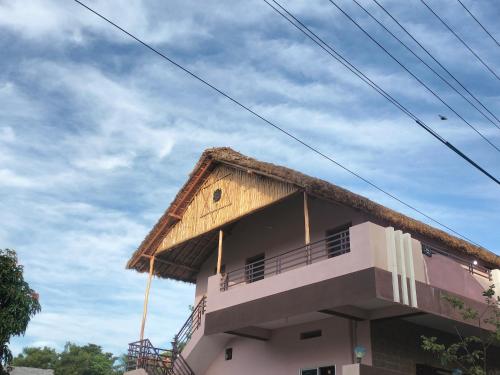 a building with a thatched roof on top of it at Prajwal home stay in Hampi