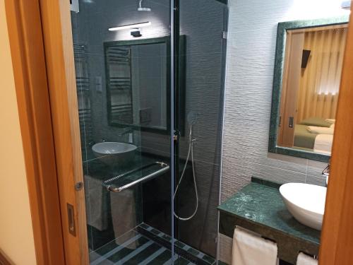 a bathroom with a glass shower and a sink at Fontanário House in Alpiarça