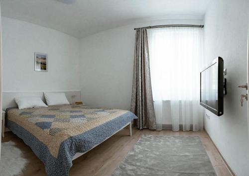 1 dormitorio con cama y ventana en Solomon Apartments ap 2 en Sîngeorgiu de Mureş