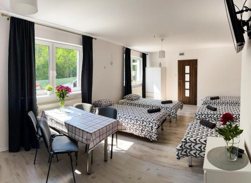 a living room with two beds and a table at Agroturystyka Mazal Dukla in Dukla