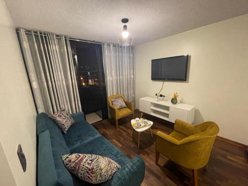 sala de estar con sofá azul y 2 sillas en Departamento completo Surquillo/Miraflores, en Lima