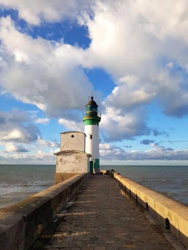 a lighthouse on a pier near the water at Chez Elise et Vincent in Eu