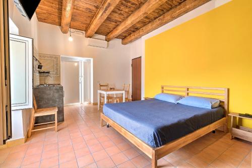 1 dormitorio con cama y pared amarilla en Villa Vesuviana, en Torre del Greco