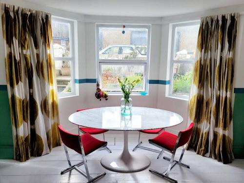 a dining room with a table and red chairs at Gorgeous 2 Bedroom Sanctuary in Kent