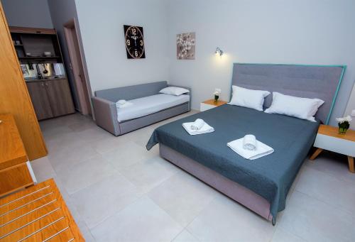 a bedroom with a bed with two towels on it at Olea Garden Apartments in Stavros