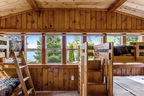 a room with three bunk beds in a cabin at Red Arbor Retreat in Arbor Vitae