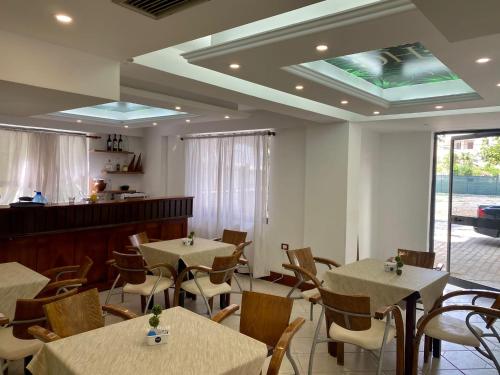 a restaurant with tables and chairs in a room at Hotel Globo in Durrës