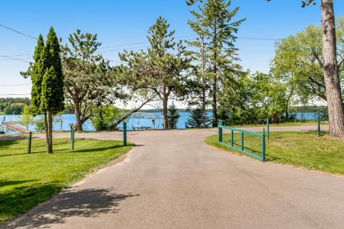 a path leading to a park with a lake in the background at Red Arbor Retreat in Arbor Vitae