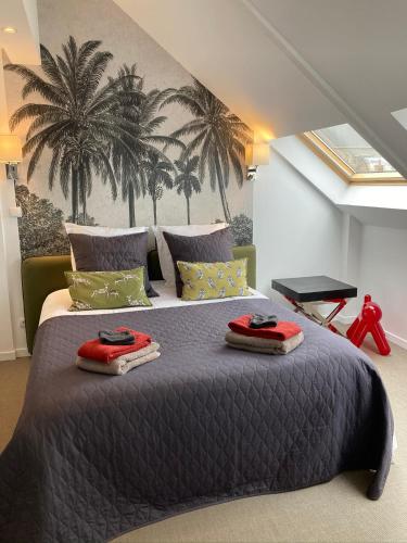 - une chambre avec un grand lit recouvert de palmiers dans l'établissement GITE Maison Nomah Maison haut standing proche plages, classé 5*, à Plouha