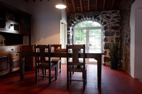 una sala da pranzo con tavolo, sedie e finestra di Coastal Trail Cottage a São Vicente Ferreira