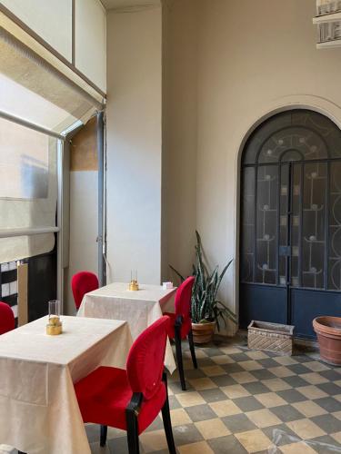un ristorante con due tavoli e sedie rosse in una stanza di DS Apartments a Catania