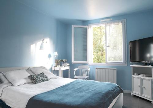 - une chambre bleue avec un lit et une télévision dans l'établissement BUD HOUSE MAGNIFIQUE VILLA PROCHE DE LA MER, à Longeville-sur-Mer