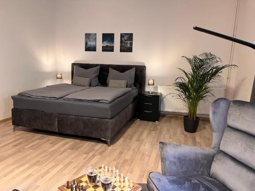 um quarto com uma cama, uma cadeira e um sofá em EXQUVISIT Suite Two em Leipzig