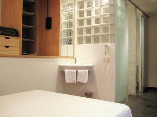 a bathroom with a bed and a sink with towels at La Plaza II in Luanco