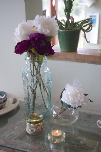 a vase filled with purple and white flowers on a table at Cinque Colori Bed & Breakfast- Spa in Algarrobo