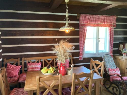 a dining room with a wooden table with a bowl of fruit at Roubenka Koněšín in Koněšín