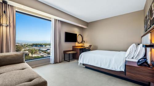 a hotel room with a bed and a large window at Hampton Inn By Hilton Nuevo Vallarta in Nuevo Vallarta 
