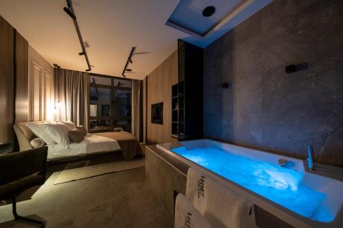 a bathroom with a tub with a bed in the background at VELVET rooms & more in Zadar