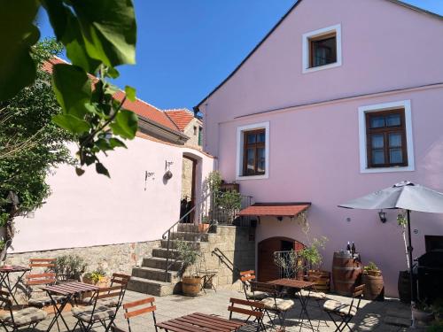 a building with tables and chairs and an umbrella at Apartmány Lavander Mikulov in Mikulov