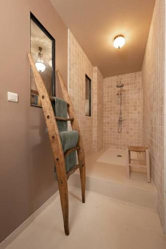 La salle de bains est pourvue d'un escalier en colimaçon en bois et d'une douche. dans l'établissement Countryhome at winery Chateau Camponac, à Bourg
