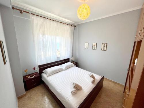 a bedroom with a bed with two towels on it at Ernest Apartments in Sarandë