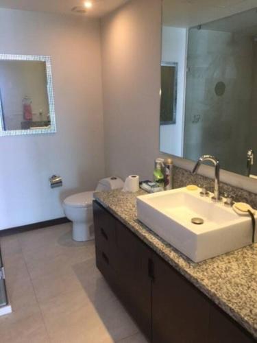 a bathroom with a sink and a toilet and a mirror at Beautiful 3 bedroom, fully furnished, on the beach in Mazatlán